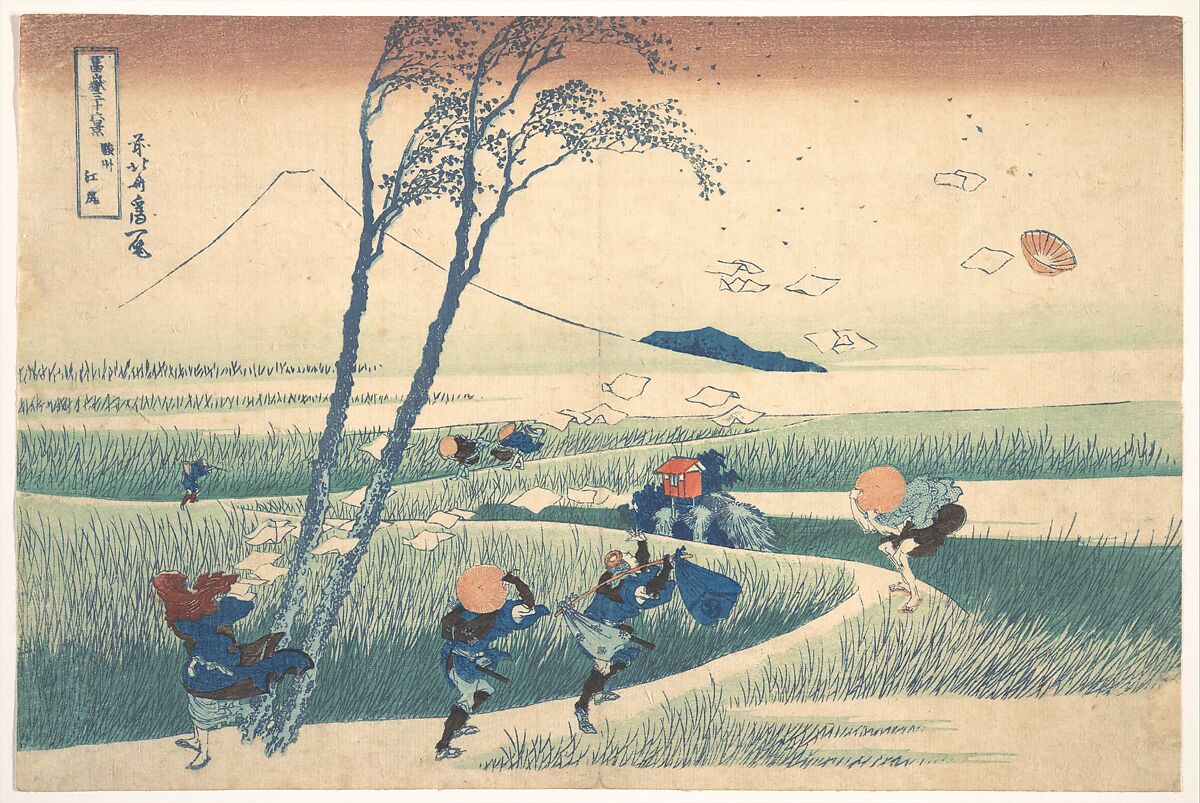 Travellers brace against wind along a curving path as papers and a hat fly, with Mount Fuji still in the distance.